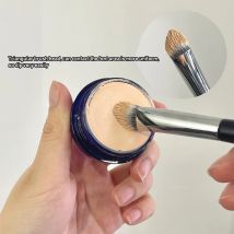 Dreieckiger, abgeschrägter Concealer, Kreise, Akne, Kosmetikpinsel, Pinsel, dunkle Augen, Concealer, Flecken, Detail, Hervorhebung von Akzenten, Make-up-Pinsel