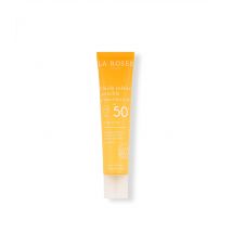 Fluide solaire invisible SPF 50+ à l’huile d’abricot BIO - Odeur Ensoleillée de coco vanille - Texture Ultra-légère, invisible, fini mat - La Rosée