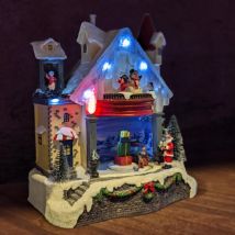 Maison du bonhomme de neige enneigée et illuminée à piles