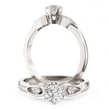 A beautiful round brilliant cut diamond ring with shoulder stones in 18ct white gold